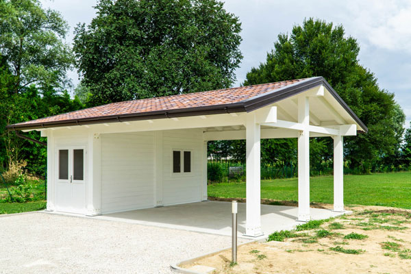 Tettoia a due falde bianca con locale chiuso e posto auto doppio